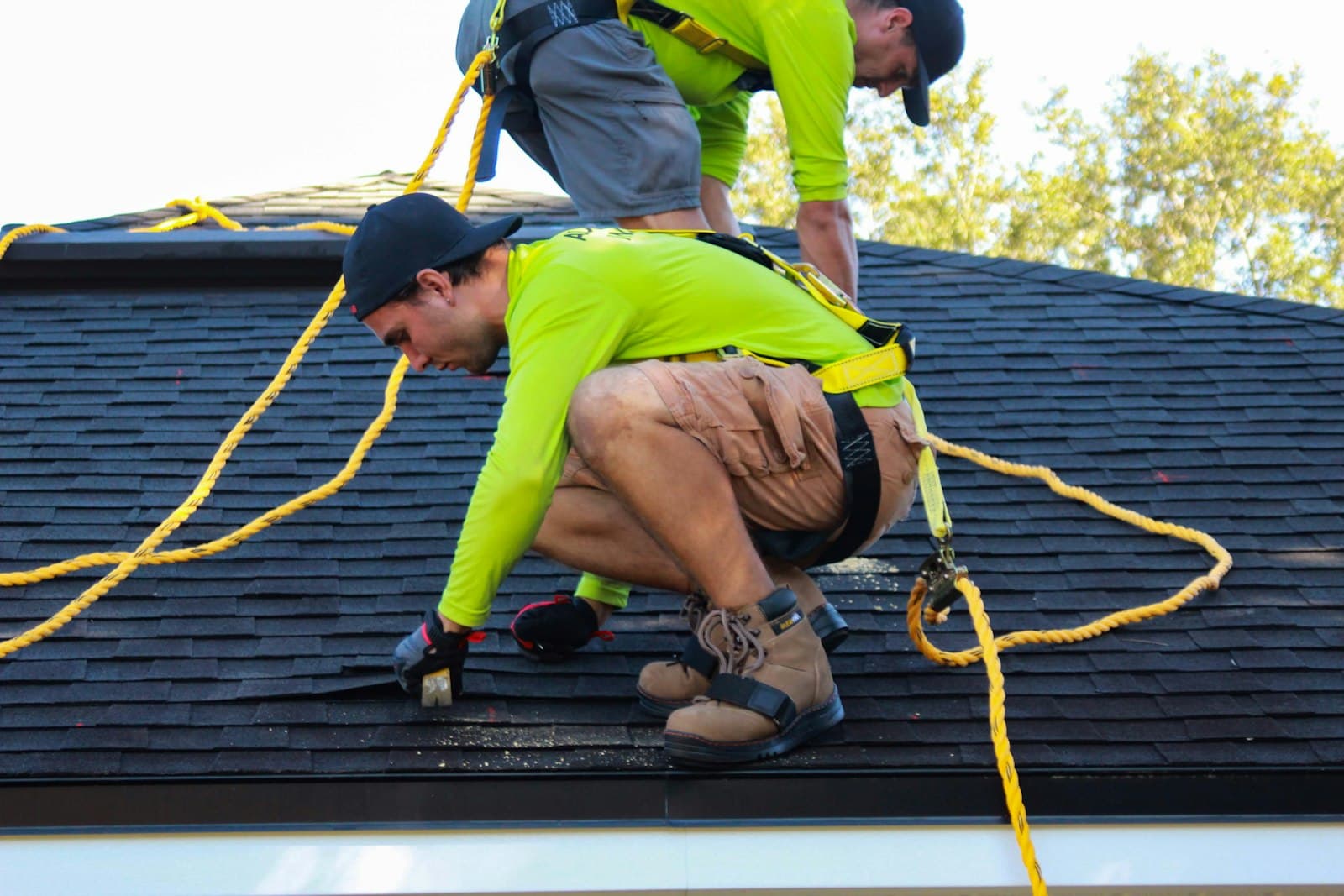 Two workers on a rooftop reviewing work during a solar or roofing installation