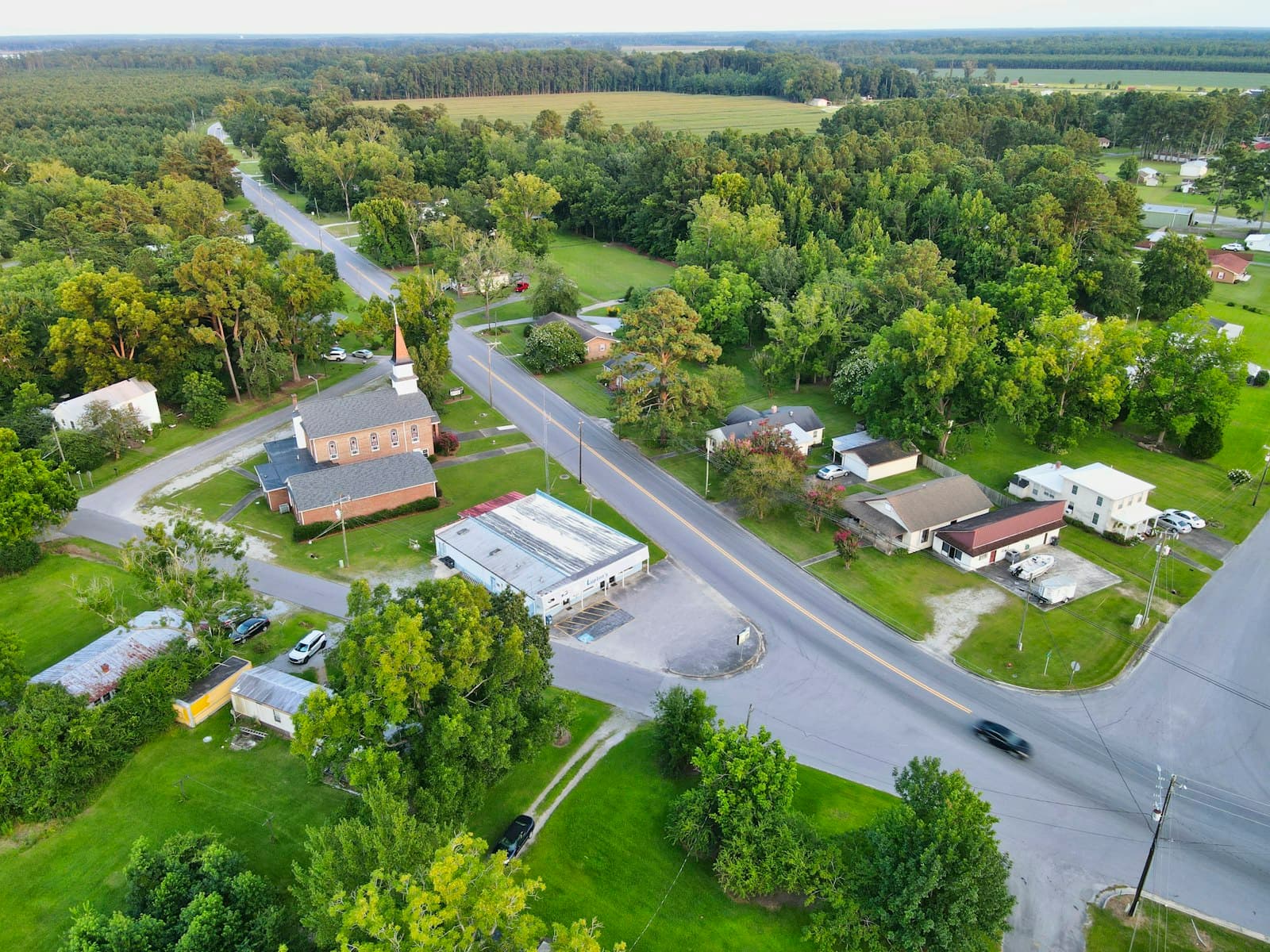Aerial view of a suburban neighborhood with green trees and houses in Stonewall, North Carolina