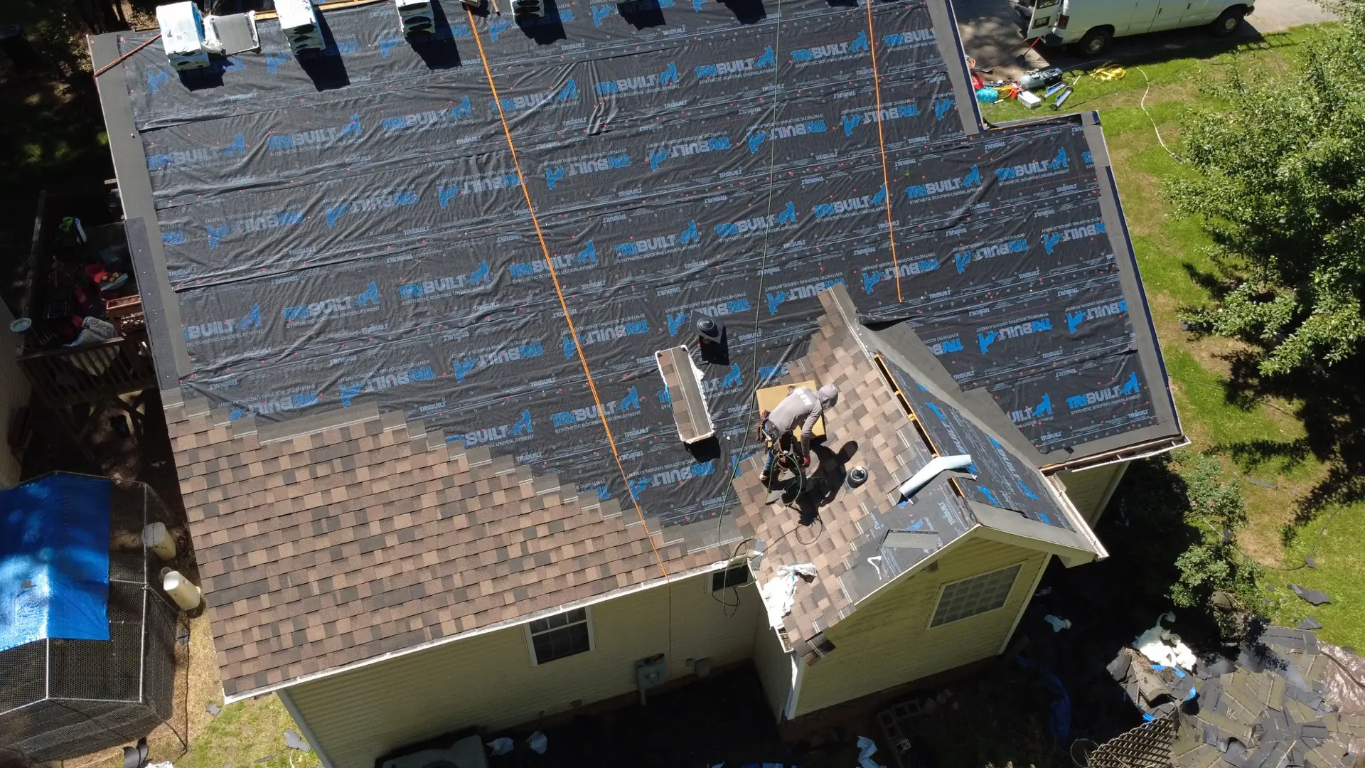 A1 crew installing synthetic underlayment on a NC roof — drone view